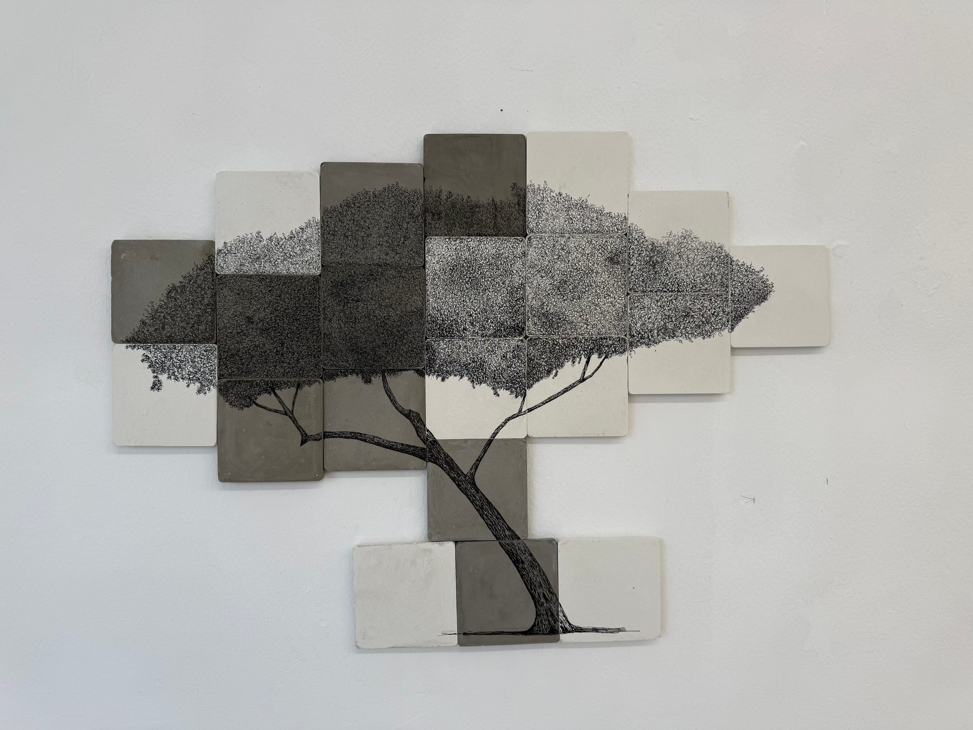Wide wall of square tiles forming a tree drawing