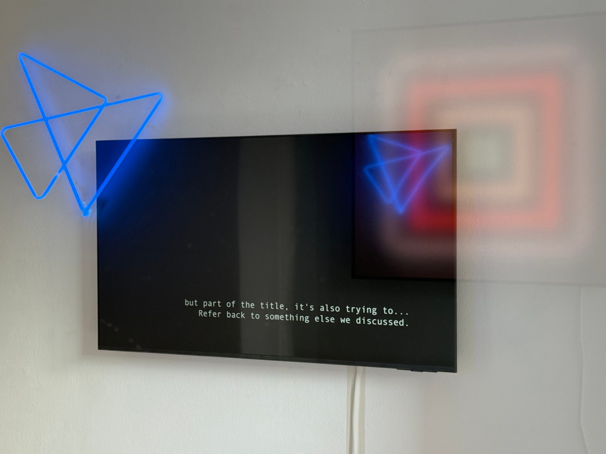 Wall-mounted screen showing a still from the film