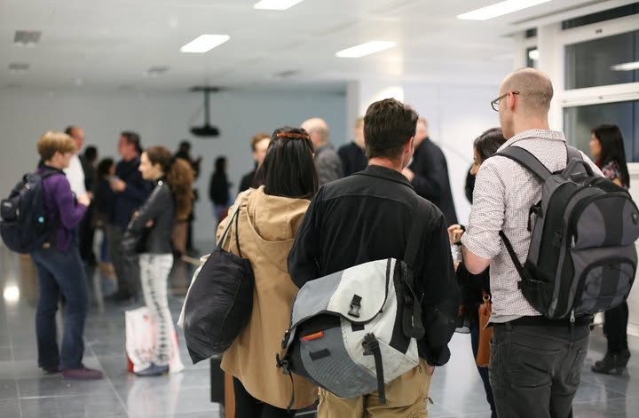 Visitors with bags and backpacks gathered in the gallery space