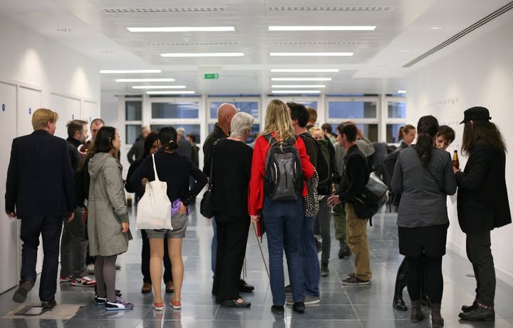 Guests mingling in the gallery hallway during the opening