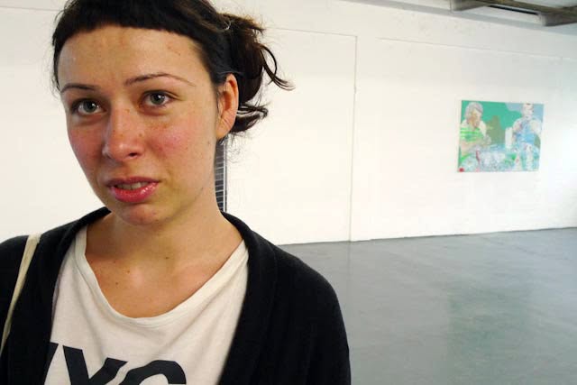 Visitor at the Deceit exhibition with artwork on the gallery wall