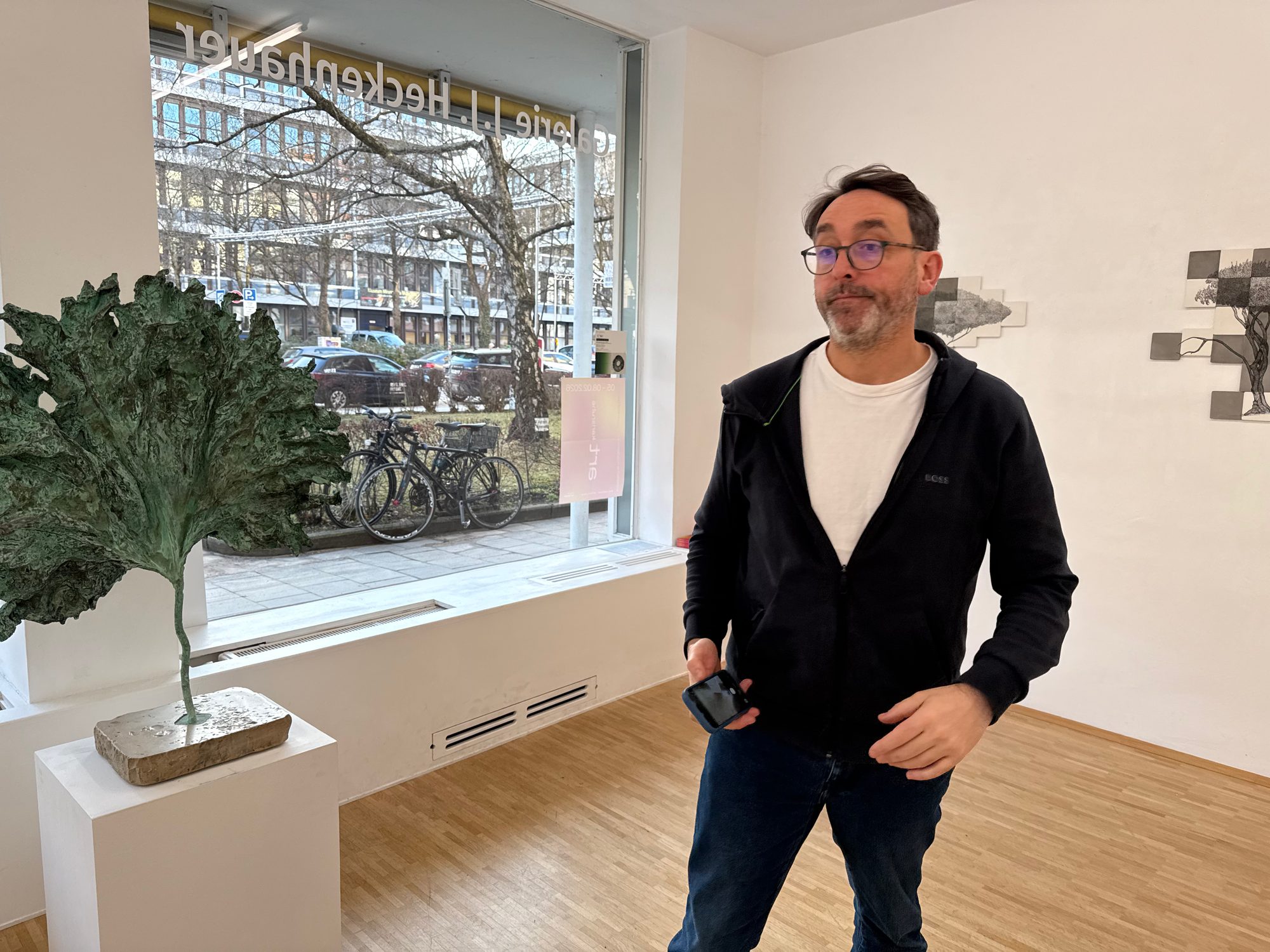 Visitor standing beside an organic sculpture in the gallery