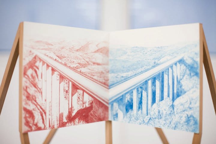 Two joined panels on a wooden stand showing mirrored viaduct drawings in red and blue
